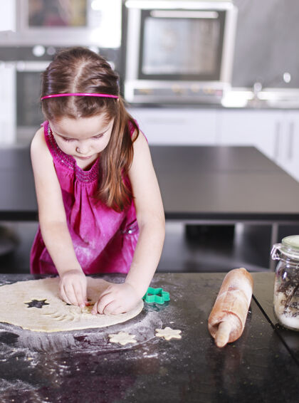准备可爱的小女孩正在学习如何做蛋糕 在家里的现代厨房桌子食物年轻