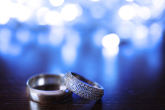 珠宝木制的结婚戒指和模糊的灯光妻子圆形庆典