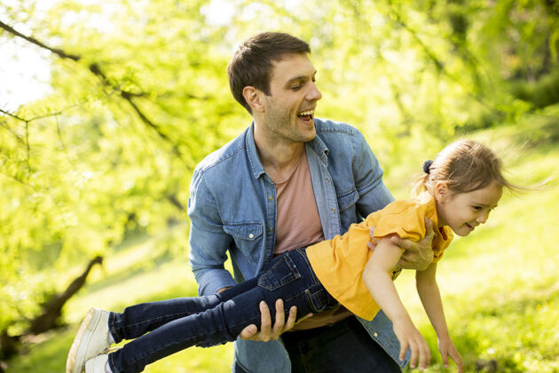 欢呼单身父亲和他可爱的小女儿在公园里玩得很开心两个家庭爱