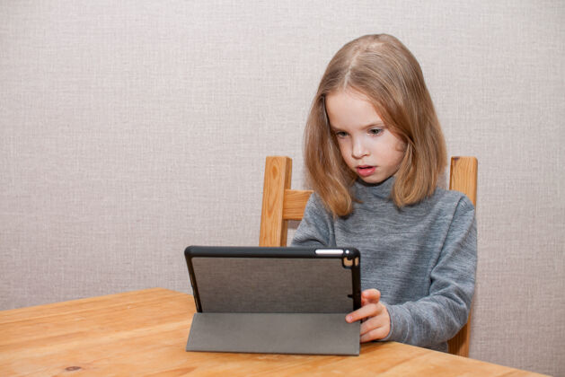 孩子小女孩正在看在线视频教程.远程培训.blog.high高质量的照片教育欢乐远程