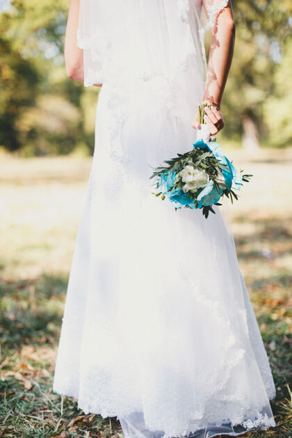 玫瑰身穿白色礼服的新娘手持婚礼花束牡丹女性花束