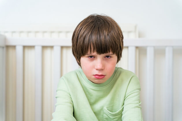 无聊一个十岁的男孩独自一人坐在家里 悲伤而不快乐尖叫烦恼年轻