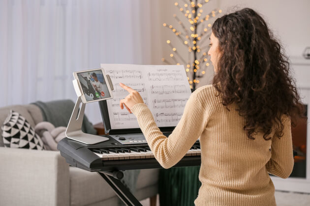 女性在家里在线上音乐课的年轻女子歌曲平板电脑人