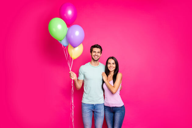 夏天照片中迷人的男女情侣手拿气球来到父母的生日派对穿着休闲装孤立的粉色背景可爱女孩模型