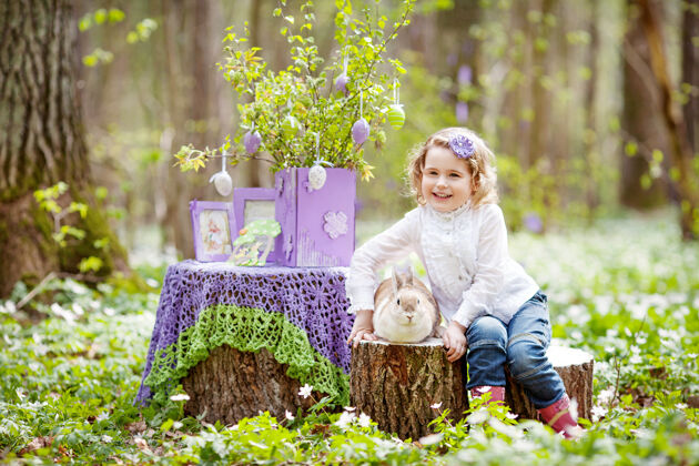 森林小女孩在花园里玩真兔子花园大笑孩子和宠物在复活节彩蛋狩猎兔子春天带宠物的孩子们享受户外乐趣一起乐趣肖像