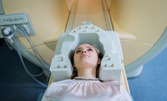 机器放射科医生为年轻女子做脑部核磁共振检查做准备技师临床癌症