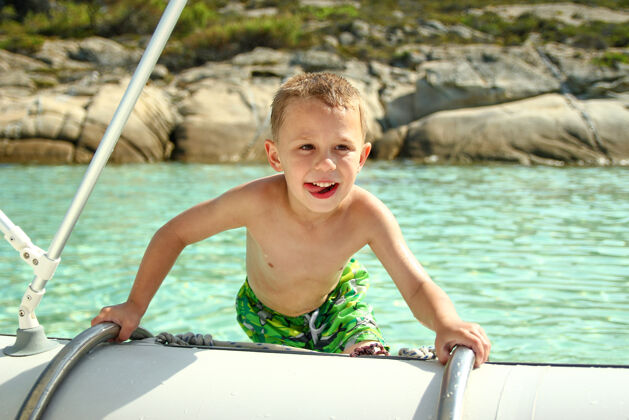 健康快乐的男孩在海边的船上船旅游欢乐