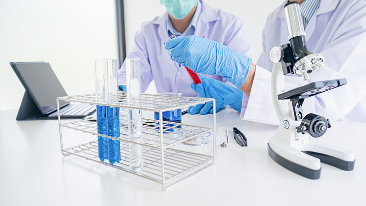 看医学或科学研究人员或男医生在实验室里看着透明溶液的试管男人化学实验室