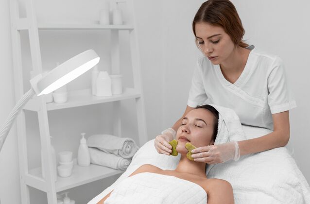 美容护理美容师为女性客户做美容常规面部护理治疗美容治疗