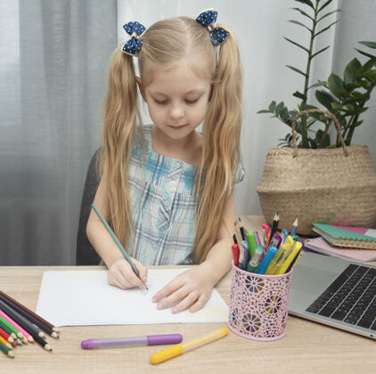 幼儿园可爱的女孩在家里的房间里做作业蜡笔纸张学校房子