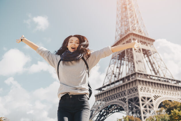 城市年轻迷人的快乐女人在巴黎的埃菲尔铁塔上欢蹦乱跳 法国肖像画当然欢呼自由快乐