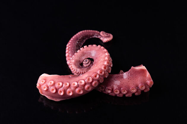 美食炖章鱼的触角被隔离在黑暗的背景上海鲜触角螺旋