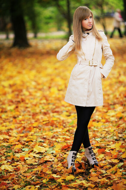 金色美丽优雅的女人站在秋天的公园里健康十月可爱