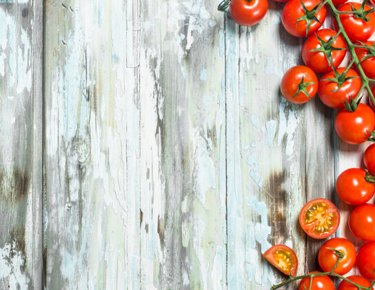 光滑红色的西红柿放在桌子上分支机构白色木质背景蔬菜水果美味