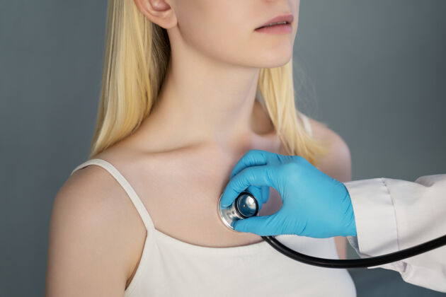 专业医生戴着防护手套用听诊器听女孩的呼吸合格提供者女人
