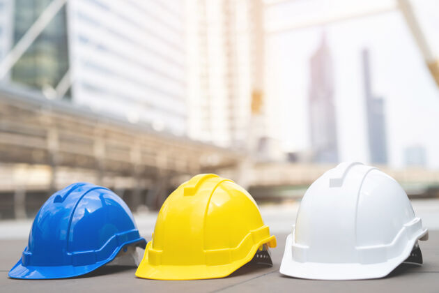 安全白 黄 蓝三种颜色的安全帽 适用于作为工程师或工人的工人的安全工程 在城市的水泥地面上检查硬装建筑师