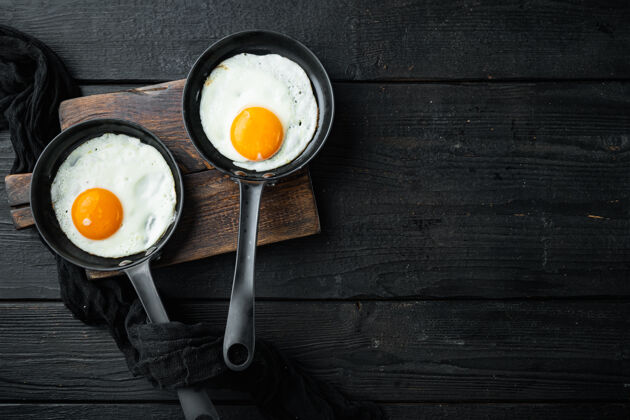鸡蛋煎蛋配培根和蔬菜 放在铸铁煎锅里 放在黑木桌上餐厅美味早晨