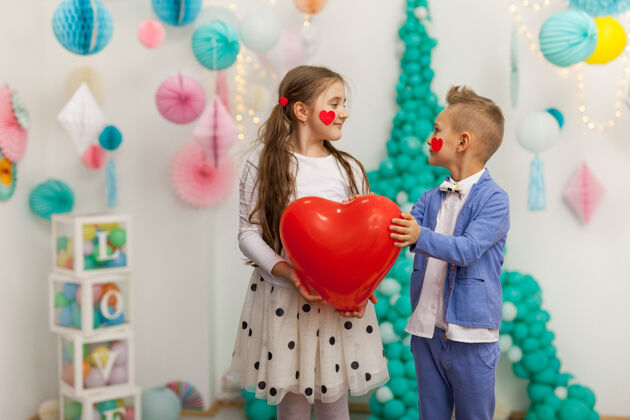 孩子一对红心可爱的孩子气球情人节 sdayandloveconcept 摄影棚拍摄礼物举行心