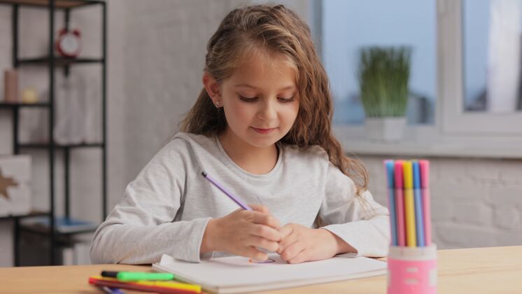 肖像小女孩用毛笔在白纸上画画相册.播放独自一人 在家里进行创造性的艺术活动室内创意微笑