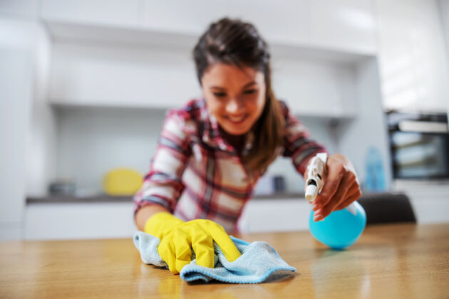 橡胶勤劳的家庭主妇用洗衣粉擦餐桌厨房女性抹布