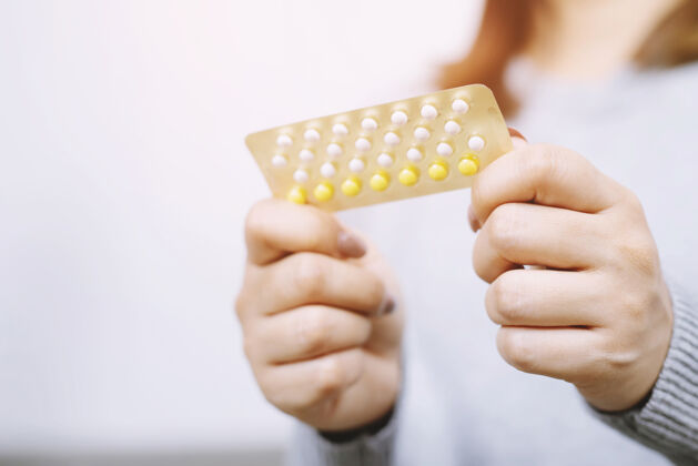 性近距离观察妇女手持避孕药避孕的概念方法控制治疗药物