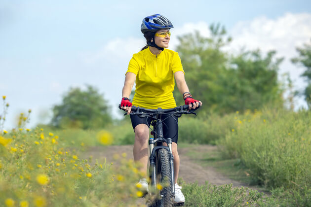 自行车手穿黄衣服的美女骑着自行车在街上自然体育以及娱乐爱好还有健康自行车自行车手小径