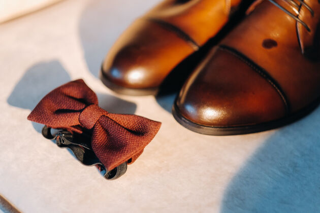 脱衣服浅背景棕色蝴蝶结和靴子蝴蝶领带优雅