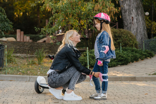 帮助妈妈帮小女儿打扮好装备和头盔 准备去公园玩赛格威头盔妈妈爱