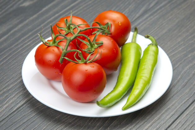 厨房红番茄和绿辣椒放在菜板上素食胡椒植物