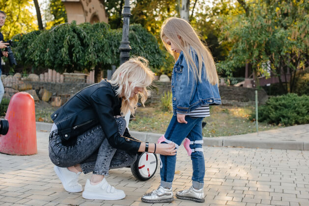 环保妈妈帮小女儿打扮好装备和头盔 准备去公园玩赛格威城市户外孩子