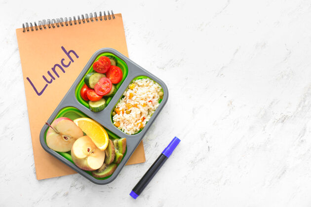 孩子学校的午餐盒里有美味的食物和笔记本水果营养部分