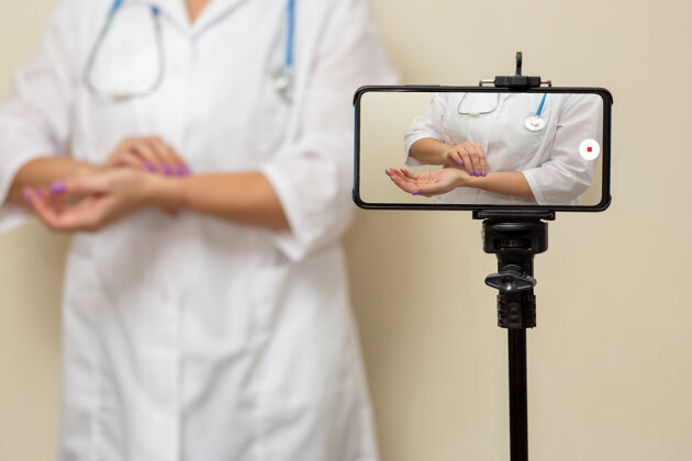 女人一位女医生在智能手机上录制了一段视频 如何测量她手臂上的脉搏诊所视频医学