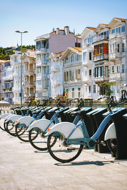 城市白色和蓝色的自行车排成一排 与伊斯坦布尔街道上美丽的房子相映成趣城市景观窗户自行车