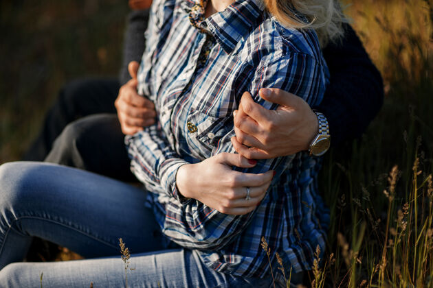 草浪漫的恋人坐在草地上拥抱日出浪漫女孩