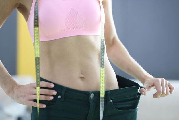 疼痛那个女人量了量她的旧牛仔裤 记录了丢失的结果体重.训练健活理念身材卡路里运动