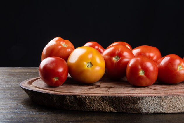 五颜六色成熟的红番茄放在木头上 配上黑色的桌子木材膳食农业