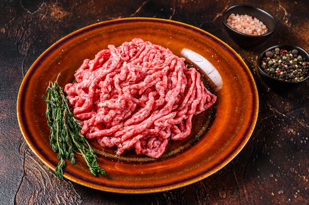 大理石生安格斯和牛肉末 磨碎的肉和香草一起放在盘子里屠夫羊肉排骨
