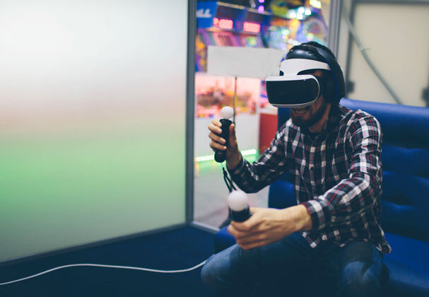 成人胡须男戴虚拟现实护目镜与虚拟现实技术在现代智能手机协同工作中的应用水平耳机 模糊沙发装备创业