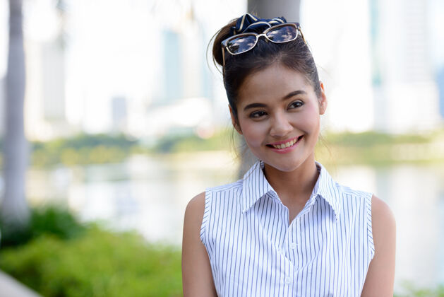 公园年轻美丽的亚洲女游客在公园户外放松的画像休闲东南风景