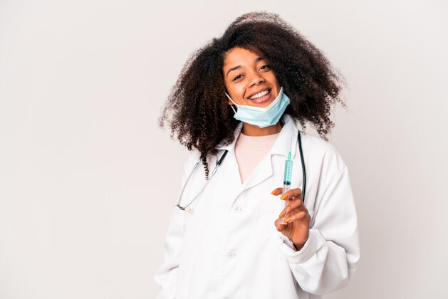 医学年轻的非洲裔美国卷发女医生拿着注射器开心地笑着 开朗地笑着卷发非洲牙齿