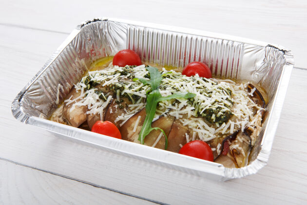 蔬菜把食物放在锡箔盒里 用茄子或茄子 樱桃番茄和帕尔玛干酪在白木桶里炖蔬菜自然帕尔玛干酪午餐