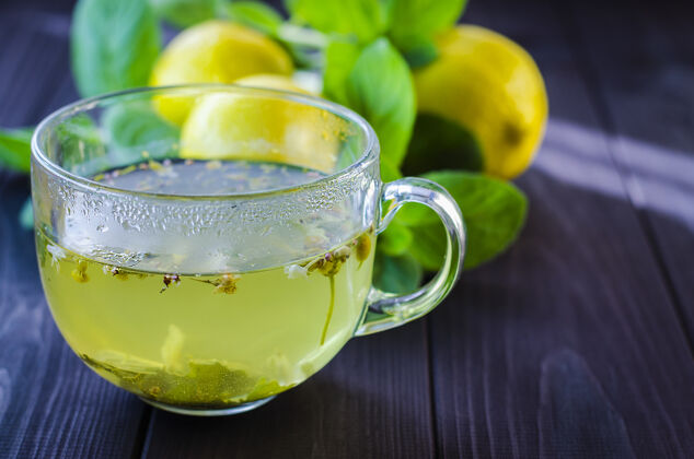 柠檬茶几上放一个透明的杯子 里面放着柠檬和薄荷玻璃健康假期