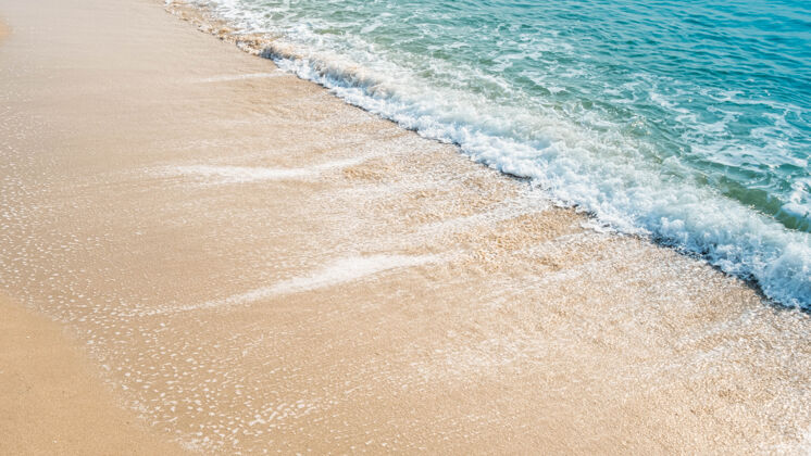 海岸沙滩上蓝色海洋的波浪纹理背景明亮海洋海滨