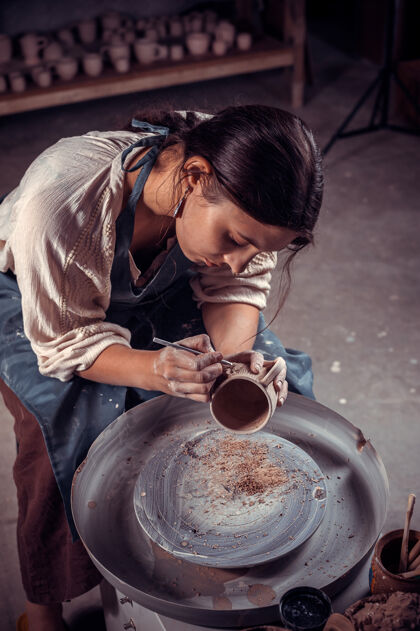 手工美丽的工匠在陶工轮子上用粘土工作手工制作创造手工