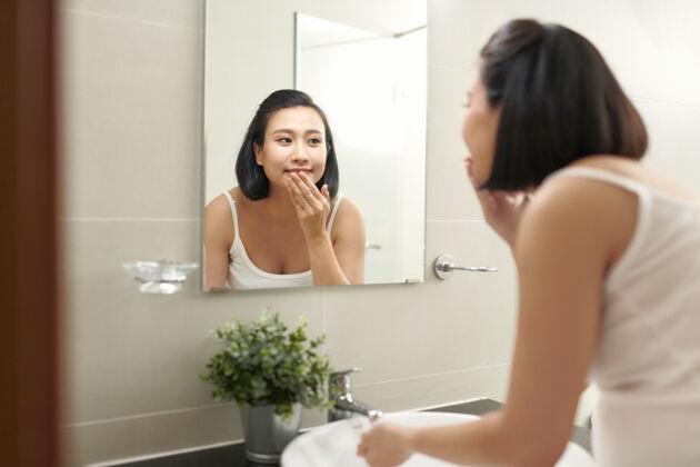 浴室孕妇在浴室水槽上方用水溅脸洗女孩韩国