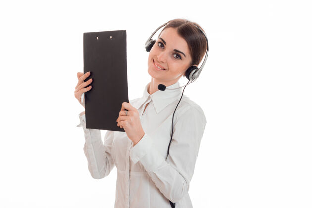 中心年轻漂亮的呼叫中心接线员穿着白衬衫 耳机和平板电脑被隔离在工作室的墙上女性现代服务