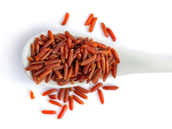 大米把一堆红米放在瓷勺上隔上白米 食物整个野生干
