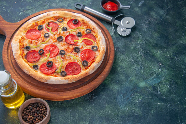 食物特写镜头美味的自制比萨饼木板番茄和油瓶辣椒番茄酱在右侧黑暗的表面射击胡椒油