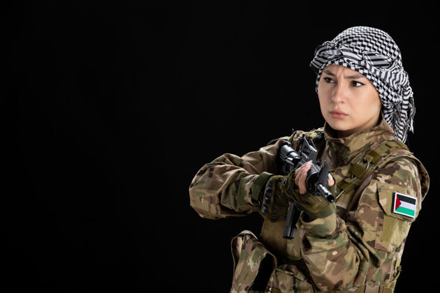 黑人穿军装的女兵把机关枪对准黑墙上枪军人女兵
