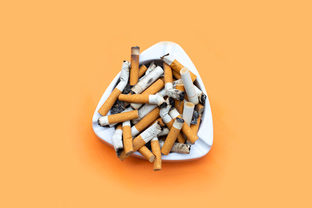 包装橙色桌子上放着烟灰缸和香烟垃圾快乐不健康
